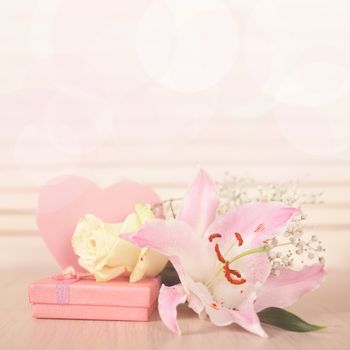 Valentines day heart shaped card, gift and flowers on wooden background