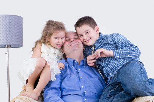 Cheerful father with two smiling children sitting together