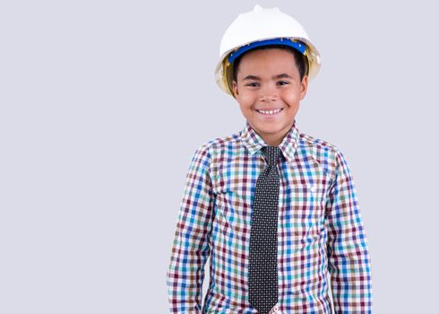 Smiling little boy wearing white hard hat and necktie with checkered shirt on gray background