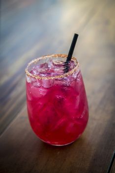 Image of a bright red cocktail on wood table