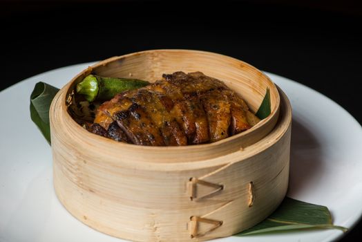 Steamed duck with okra in bamboo bowl