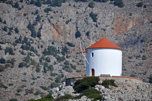 This traditional Greek windmill overlooks the bay at Panormitis Monastery on the Island of Symi, near Rhodes.