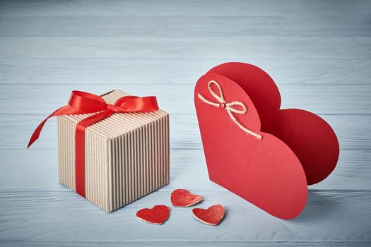 Valentines Day. Love heart, gift box, ribbon handmade  red paper card. Vintage retro romantic style. Marriage proposal concept. Unusual creative greeting card, wooden blue background, copyspace, toned