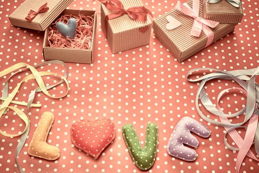 Love, Valentines Day. Word Love polka dots, Heart Handmade and stack of gift boxes, ribbons. Retro vintage romantic style, toned. Vivid unusual creative art greeting card, multicolored felt, copyspace