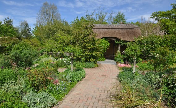 Thatched summerhouse in an English style garden. Taken at RHS Rosemoor, Torrington, North Devon, England