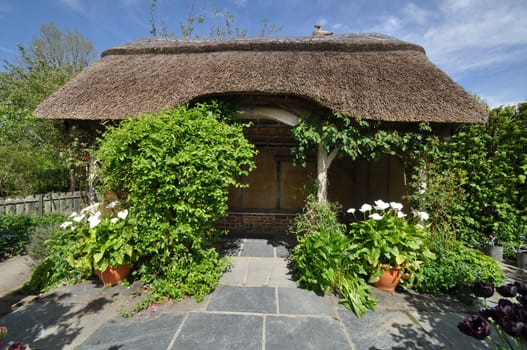 Thatched summerhouse in an English style garden. Taken at RHS Rosemoor, Torrington, North Devon, England