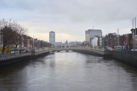 DUBLIN, IRELAND - JANUARY 05: Side view of Ha'penny Bridge over Liffey river. The bridge is the main access point to the touristic area of Temple Bar. January 05, 2016 in Dublin