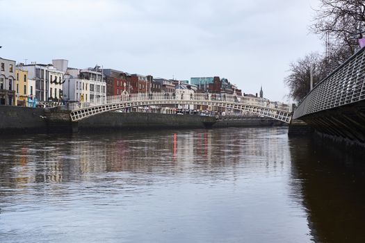 DUBLIN, IRELAND - JANUARY 05: Side view of Ha'penny Bridge over Liffey river. The bridge is the main access point to the touristic area of Temple Bar. January 05, 2016 in Dublin