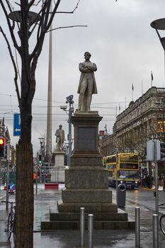 DUBLIN, IRELAND - JANUARY 05: Statue of William Smith O'Brien with Millennium Spire and statue of John Gray in the background, in overcast day. January 05, 2016 in Dublin
