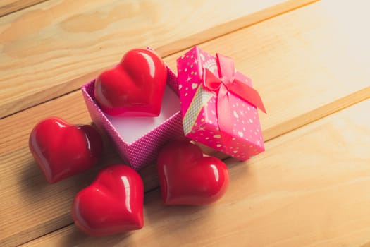 Gift of love. hearty gift. A gift box with a red heart inside. On the wooden floor