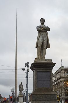 DUBLIN, IRELAND - JANUARY 05: Statue of William Smith O'Brien with Millennium Spire in the background, in overcast day. January 05, 2016 in Dublin
