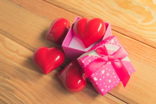 Gift of love. hearty gift. A gift box with a red heart inside. On the wooden floor