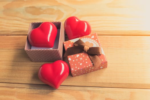 Gift of love. hearty gift. A gift box with a red heart inside. On the wooden floor