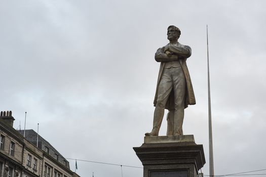 DUBLIN, IRELAND - JANUARY 05: Statue of William Smith O'Brien with Millennium Spire in the background, in overcast day. January 05, 2016 in Dublin