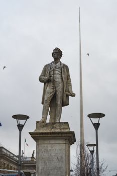 DUBLIN, IRELAND - JANUARY 05: Statue of John Gray with Millennium Spire in the background, in overcast day. January 05, 2016 in Dublin