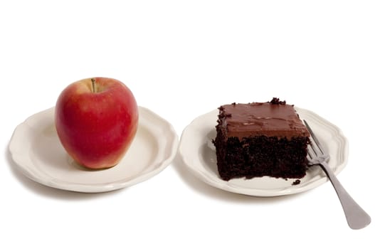 Trying to make a choice of eating a healthy apple or an unhealthy cake.