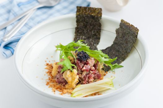 Raw dry-aged beef with herbs, seaweed and soup, Modern cuisine in Japanese style
