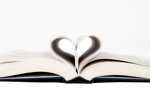 Opened book with pages in shape of heart.  On white background