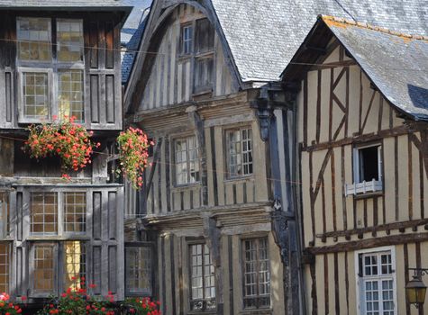 Medieval half-timbered buildings in the ancient french town of Dinan in Brittany. These old buildings are in the Place des Merciers (Haberdashers Square)~ One of  the areas of Dinan most visited by tourists.