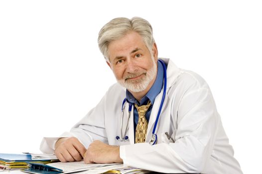 Horizontal shot of a tired but happy doctor sitting at his desk.