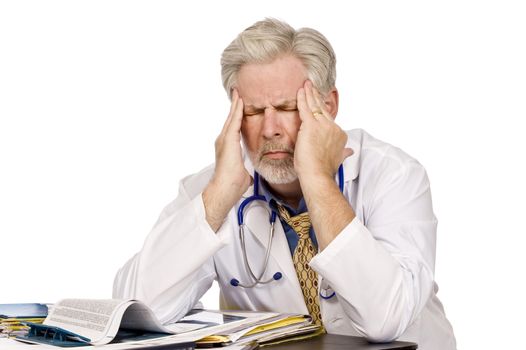 Horizontal shot of a tired doctor at his desk with a bad headache.