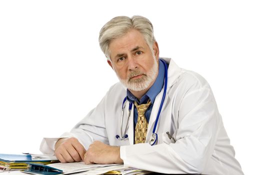 Horizontal shot of a tired doctor sitting at his desk.  Shot on white background.