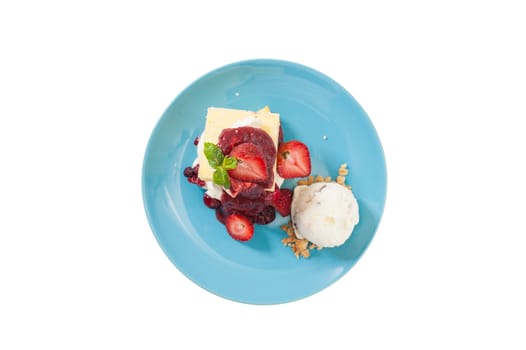 Yellow cake and vanilla ice cream dressed with strawberry sauce on blue dish isolated on white background with clipping path