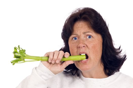 Overweight woman trying hard to bite into a healthy vegetable like celery, but not happy about it.