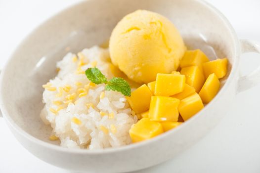 Mango with sticky rice and mango sherbet ice cream in ceramic bowl