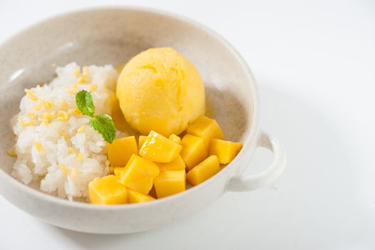 Mango with sticky rice and mango sherbet ice cream in ceramic bowl