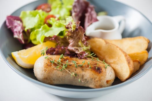 Grilled sausage with fried potatoes and salad