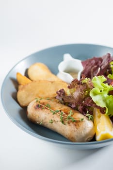 Grilled sausage with fried potatoes and salad