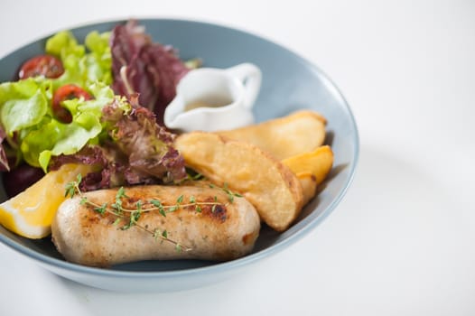 Grilled sausage with fried potatoes and salad