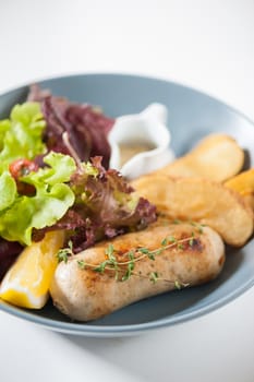 Grilled sausage with fried potatoes and salad