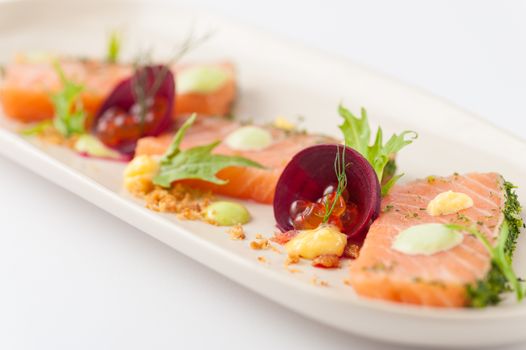Smoked salmon with herbs, beetroot, faked salmon roe (sauce cooked by molecular gastronomy technic) garnished with mago sauce and wasabi mayo