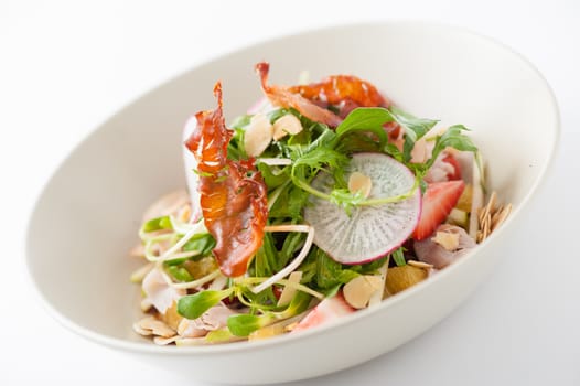 Vegetables and fruits salad with balsamic vinegar and navel orange dressing and smoked striploin ham 1.5 millimeters thickness in ceramic bowl, a modern cusine concept food