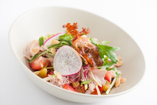 Vegetables and fruits salad with balsamic vinegar and navel orange dressing and smoked striploin ham 1.5 millimeters thickness in ceramic bowl, a modern cusine concept food
