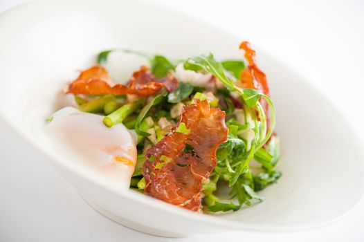 Vegetables salad with balsamic vinegar dressing, onsen tamago (Japanese style scald egg) and smoked striploin ham 1.5 millimeters thickness in ceramic bowl, a modern cusine concept food