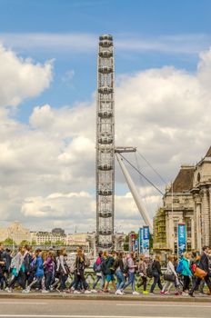 LONDON - MAY 28: Tourists on Westminster Bridge with London Eye on background, May 28, 2015. The ferris wheel is 135 metres (443 ft) tall and the wheel has a diameter of 120 metres (394 ft)