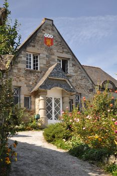 Old stone house bearing heralric coat of arms in the medieval street of Rue de Jerzual, Dinan, Brittnay, France.