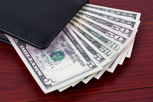 Wallet with American dollars on a wooden background