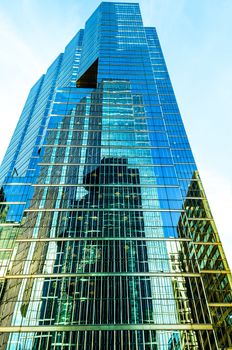 Huge its modern office building with infinity drifting in a blue sky.