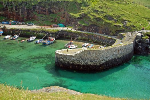 The village of Boscastle site on the Atlantic coast in north Cornwall, in the southwest of England. The little village has a small fleet of little fishing boats seen here behind the harbour wall. Boscastle here is a tranquil idylic place but some years ago it made global news when a flash flood washed much of the village away. Today it is once again a wonderfully peacefuland picturesque place to visit 