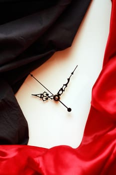 Abstract background with clock face between red and black textile