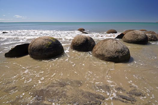 Moeraki Boulders are perfectly spherical rocks on the beach at Moeraki, north of Dunedin, near Oamaru. Up to 13 feet round Maori believe they were food baskets on the original Maori canoe