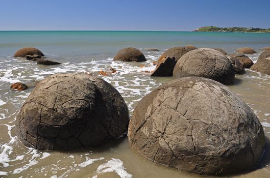 Moeraki Boulders are perfectly spherical rocks on the beach at Moeraki, near Oamaru. Up to 13 feet round Maori believe they were canoe food baskets.