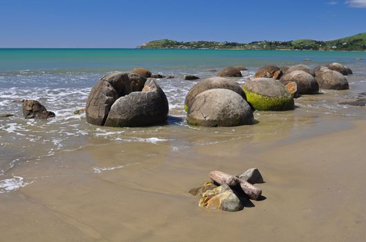 Moeraki Boulders are perfectly spherical rocks on the beach at Moeraki, near Oamaru. Up to 13 feet round Maori believe they were canoe food baskets.