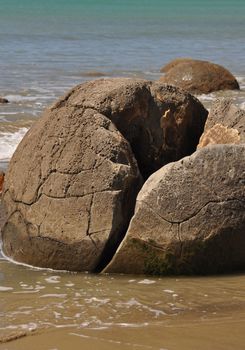 Moeraki Boulders are perfectly spherical rocks on the beach at Moeraki, near Oamaru. Up to 13 feet round Maori believe they were canoe food baskets.