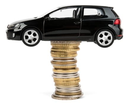 Car on stack of coins isolated on white background, side view