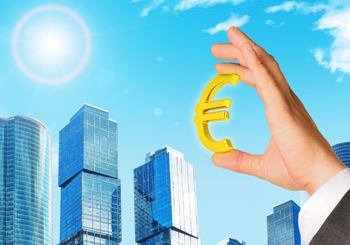 Businessman hand with euro sign on city background